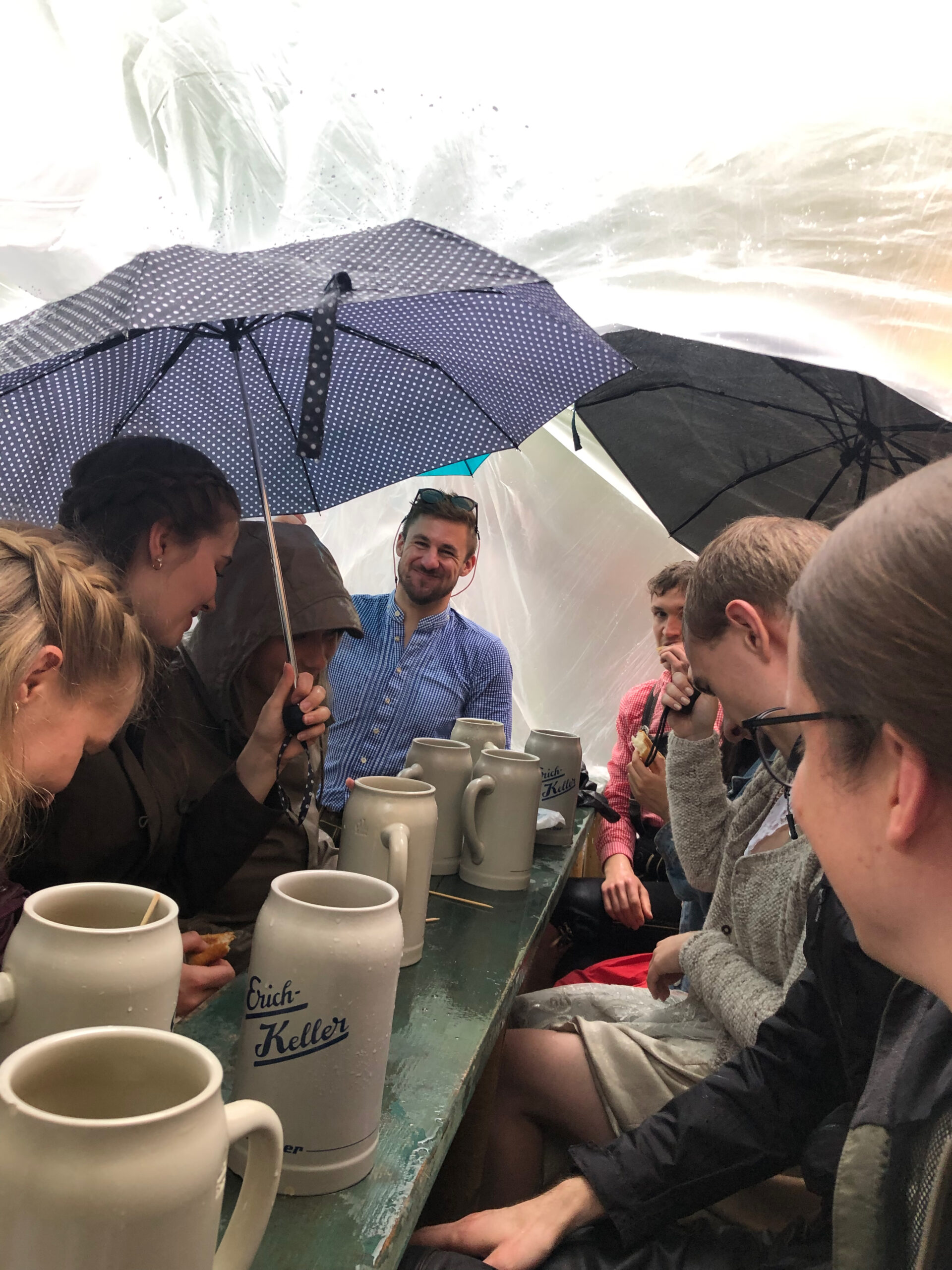 BVT Mitarbeitenden unter der Planne und Regenschirmen im Regen beim Bergkirchweih