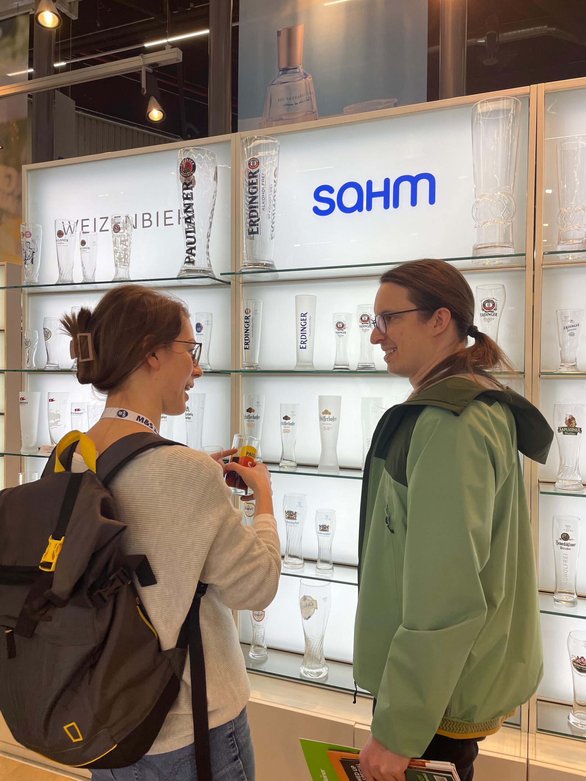 Stefanie Fritzsche und Patrik Blenk beim Gespräch vor dem Regal mit Biergläser