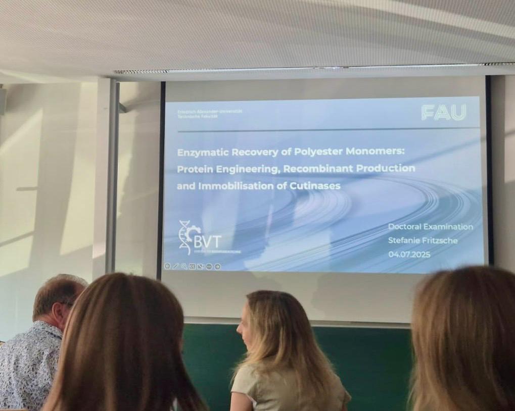 Die Titelfolie des Vortrages im Seminarraum mit vier Teilnehmern im Bild