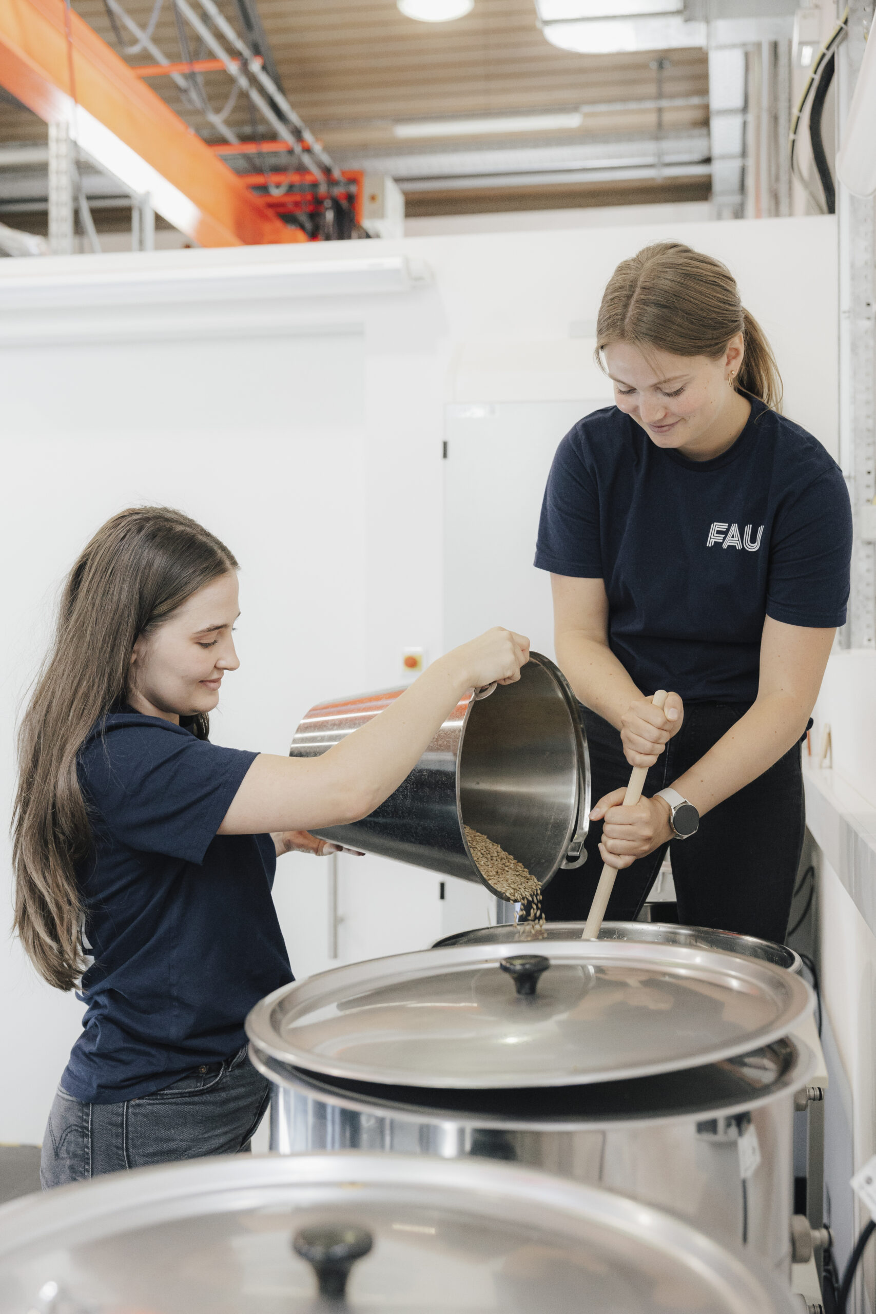 Zwei weibliche Mitglieder des Brauteams bei Malzzugabe