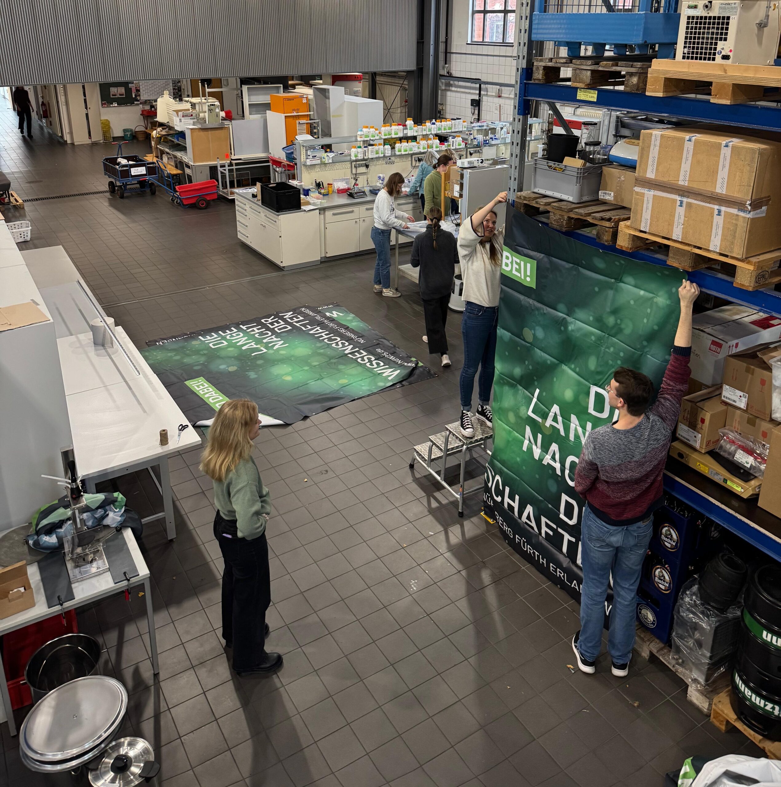 füne Personen in einer Halle bei der Vorbereitung für die Lange Nacht der Wissenschaftenen zur