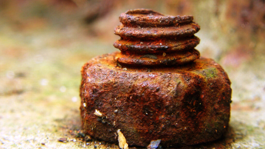 Eine Korrodierte Schraube am Boden im Wasser